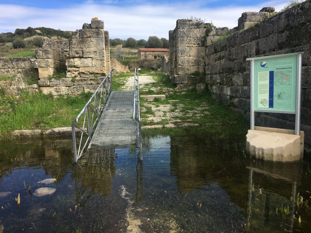 The main gates and the pond that blocks the walkway around the site